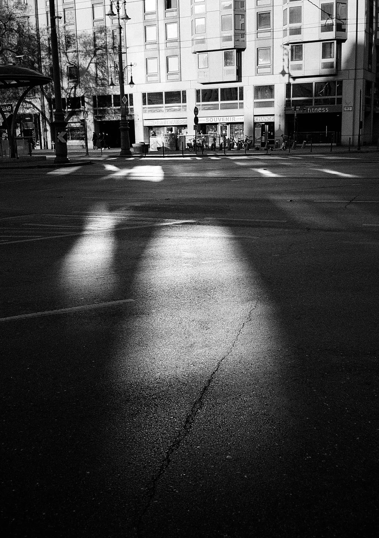 A narrow city street between tall buildings, in black and white.
